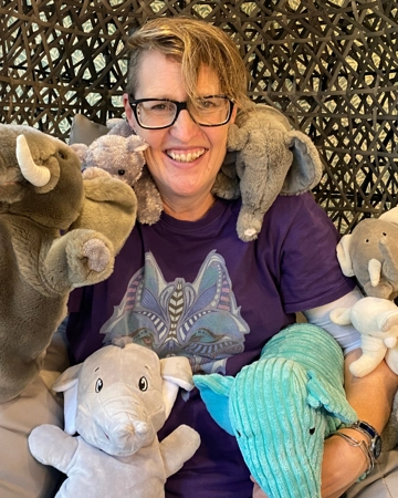 Woman is surrounded by soft toys